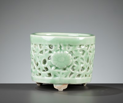 Lot 494 - A LONQUAN CELADON-GLAZED RETICULATED TRIPOD CENSER, LATE MING TO EARLY QING DYNASTY