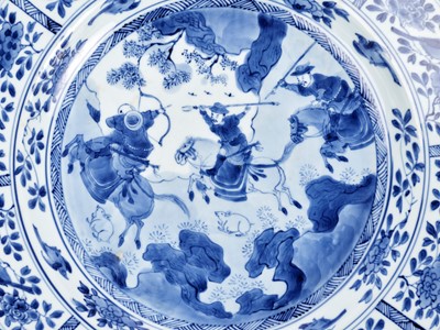 Lot 72 - A LARGE BLUE AND WHITE ‘HUNTING SCENE’ DISH, KANGXI PERIOD