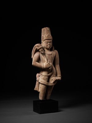 Lot 590 - A LARGE AND MASSIVE SANDSTONE FIGURE OF A CHAURI BEARER, 10TH CENTURY