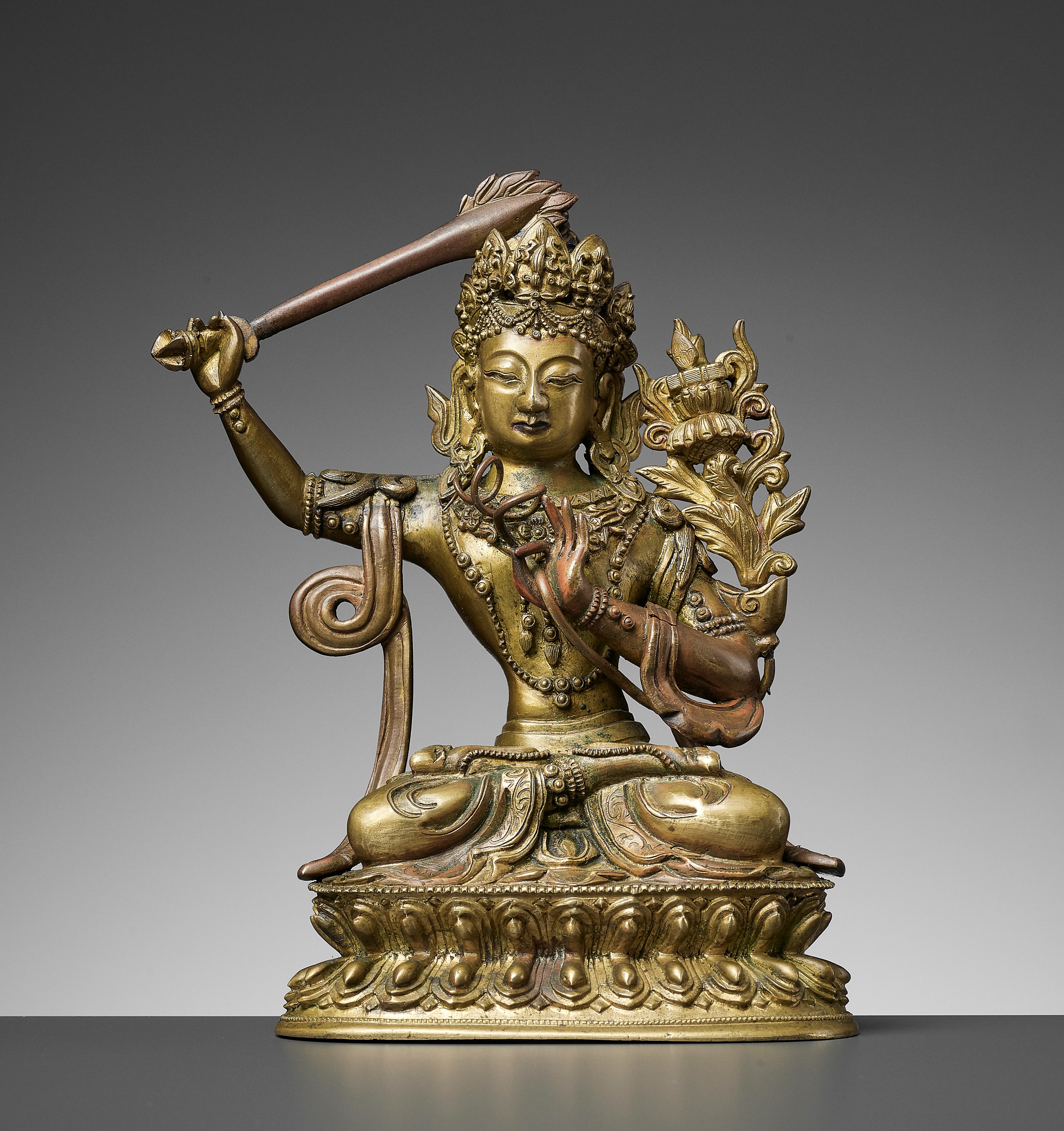 Lot 385 - A GILT BRONZE FIGURE OF MANJUSHRI, QIANLONG