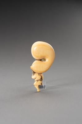 Lot 522 - AN IVORY NETSUKE OF A MAN CARRYING A HUGE DOUBLE GOURD