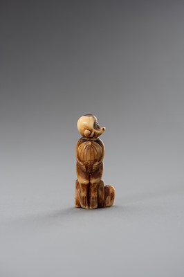 Lot 200 - A STAG ANTLER NETSUKE OF A MONKEY HOLDING A PEACH