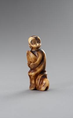 Lot 200 - A STAG ANTLER NETSUKE OF A MONKEY HOLDING A PEACH