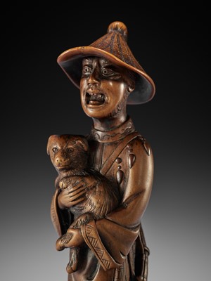 Lot 15 - A VERY LARGE AND SUPERB WOOD NETSUKE OF A FOREIGNER WITH DOG