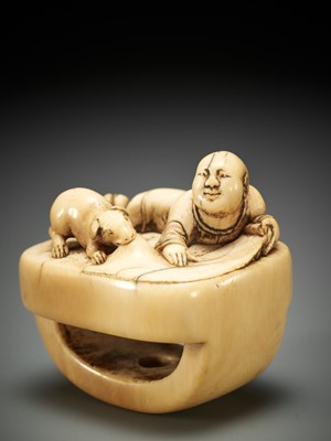 Lot 168 - A CHARMING OLD IVORY NETSUKE WITH A BOY, SCROLL AND DOG