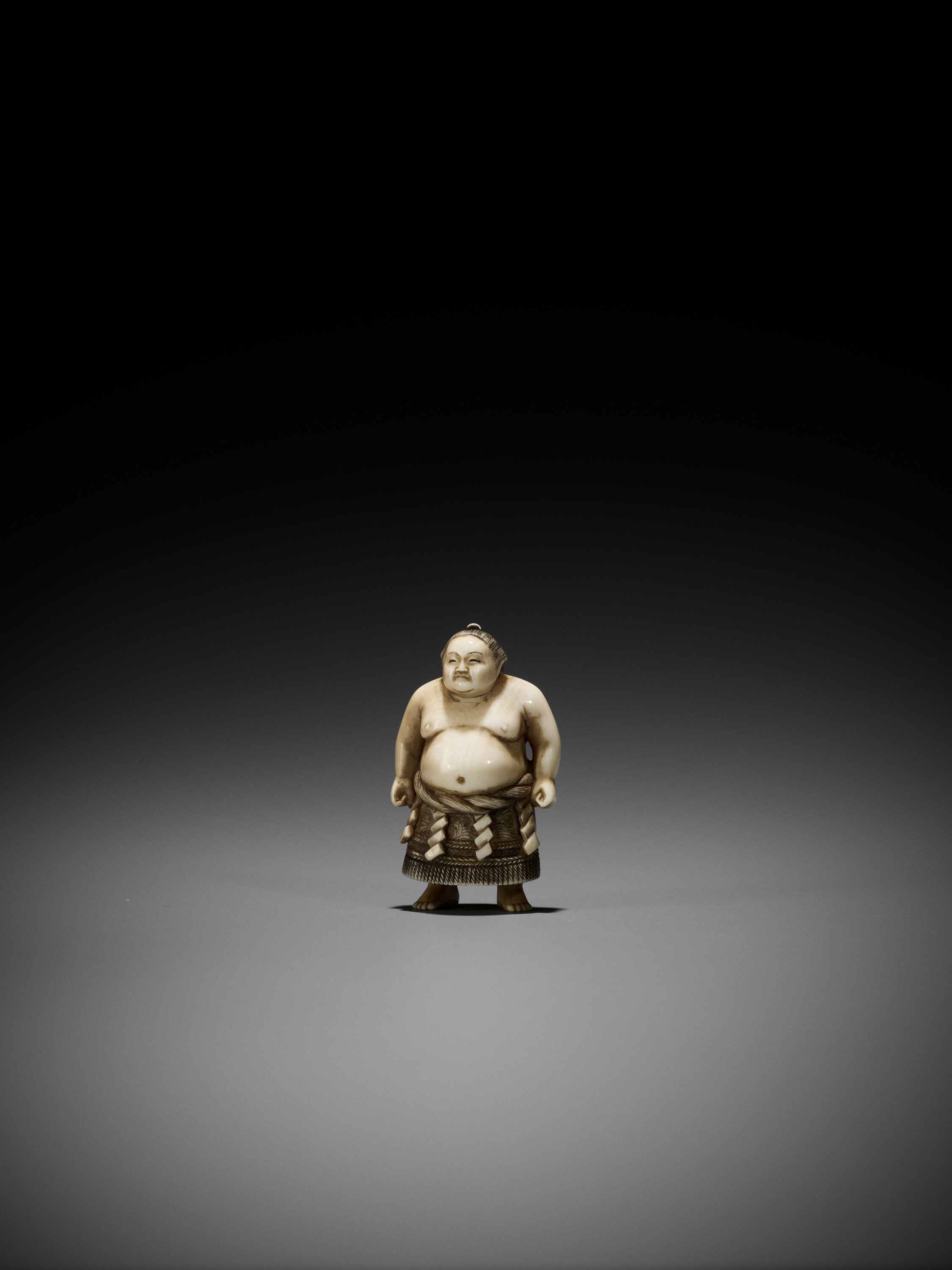 Lot 243 - TADAYOSHI: AN IVORY NETSUKE OF A YOKOZUNA