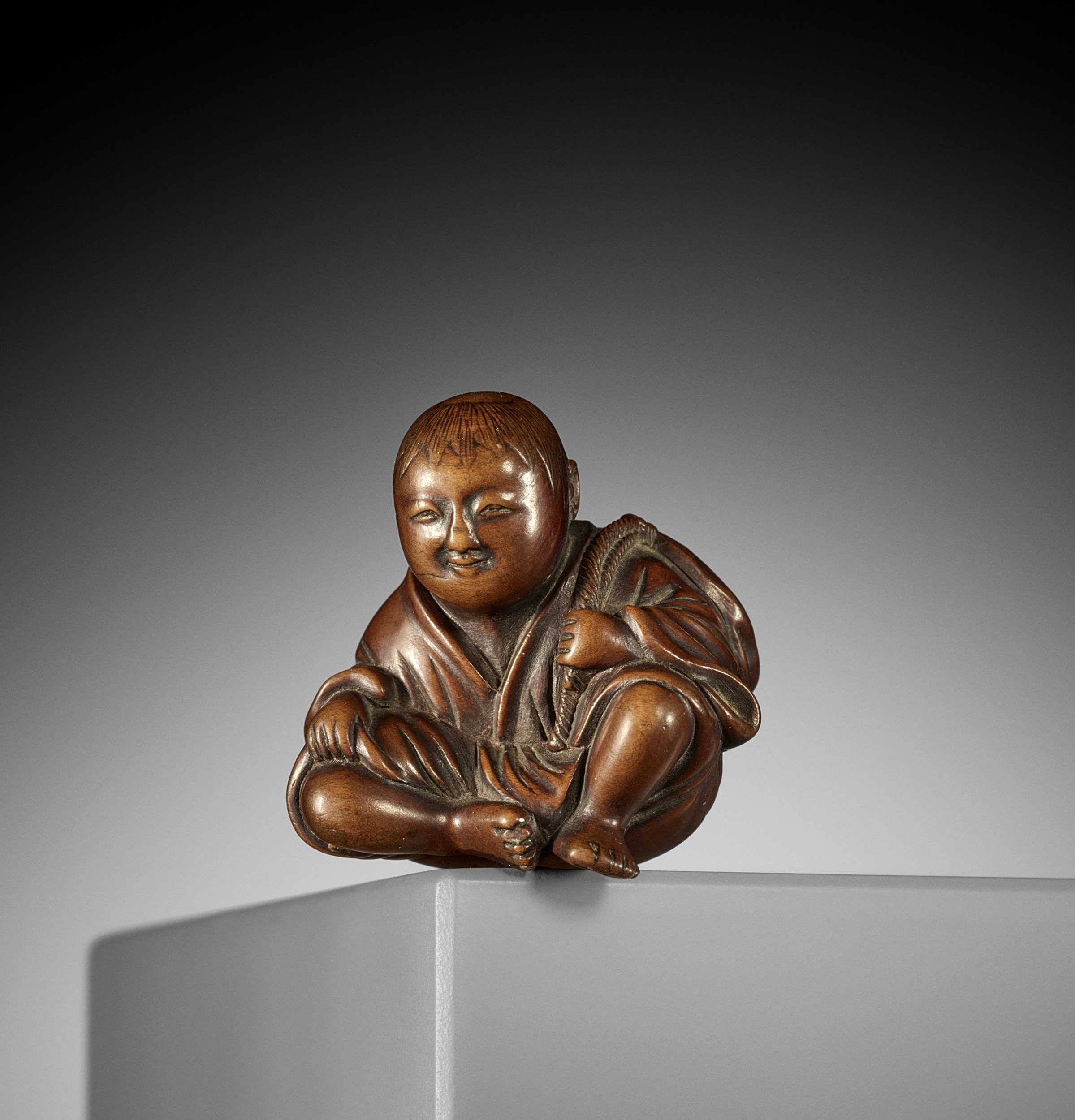 Lot 440 - A CHARMING WOOD NETSUKE OF A RESTING FARMER