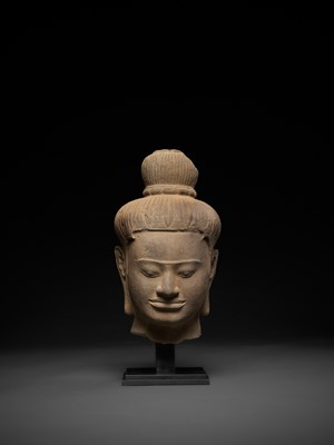 Lot 566 - A LARGE SANDSTONE HEAD OF A MALE DEITY, BAPHUON STYLE, ANGKOR PERIOD