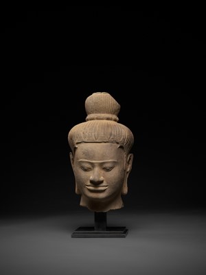 Lot 566 - A LARGE SANDSTONE HEAD OF A MALE DEITY, BAPHUON STYLE, ANGKOR PERIOD