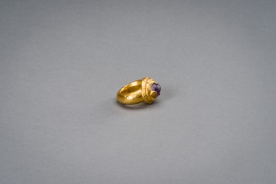 Lot 1168 - A LARGE KHMER GOLD RING WITH AMETHYST