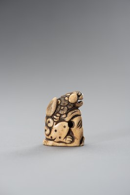 Lot 493 - A STAG ANTLER NETSUKE OF A SHISHI ON A ROCK