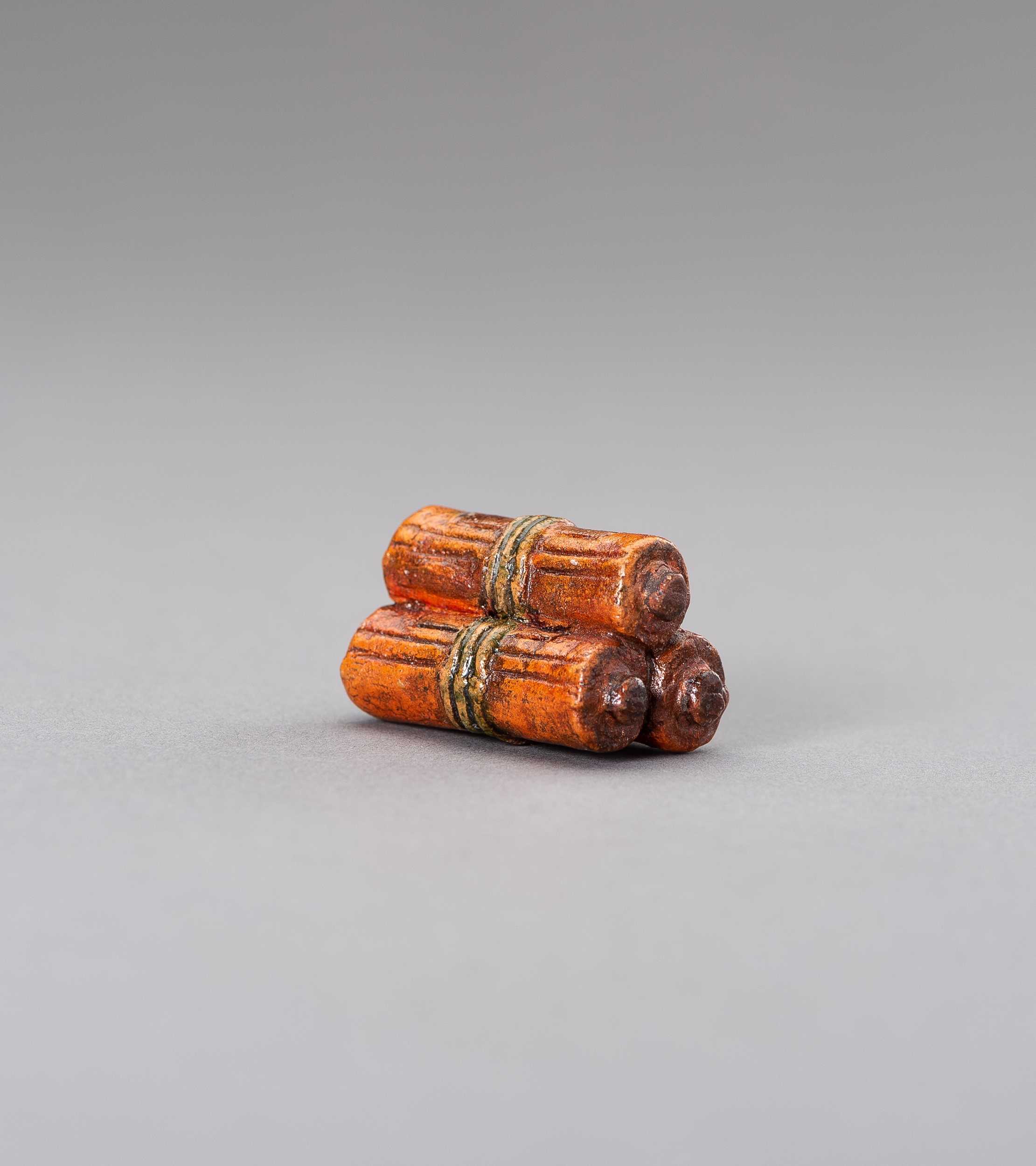 Lot 471 - A YAKIMONO CERAMIC NETSUKE OF BUDDHIST SUTRA SCROLLS