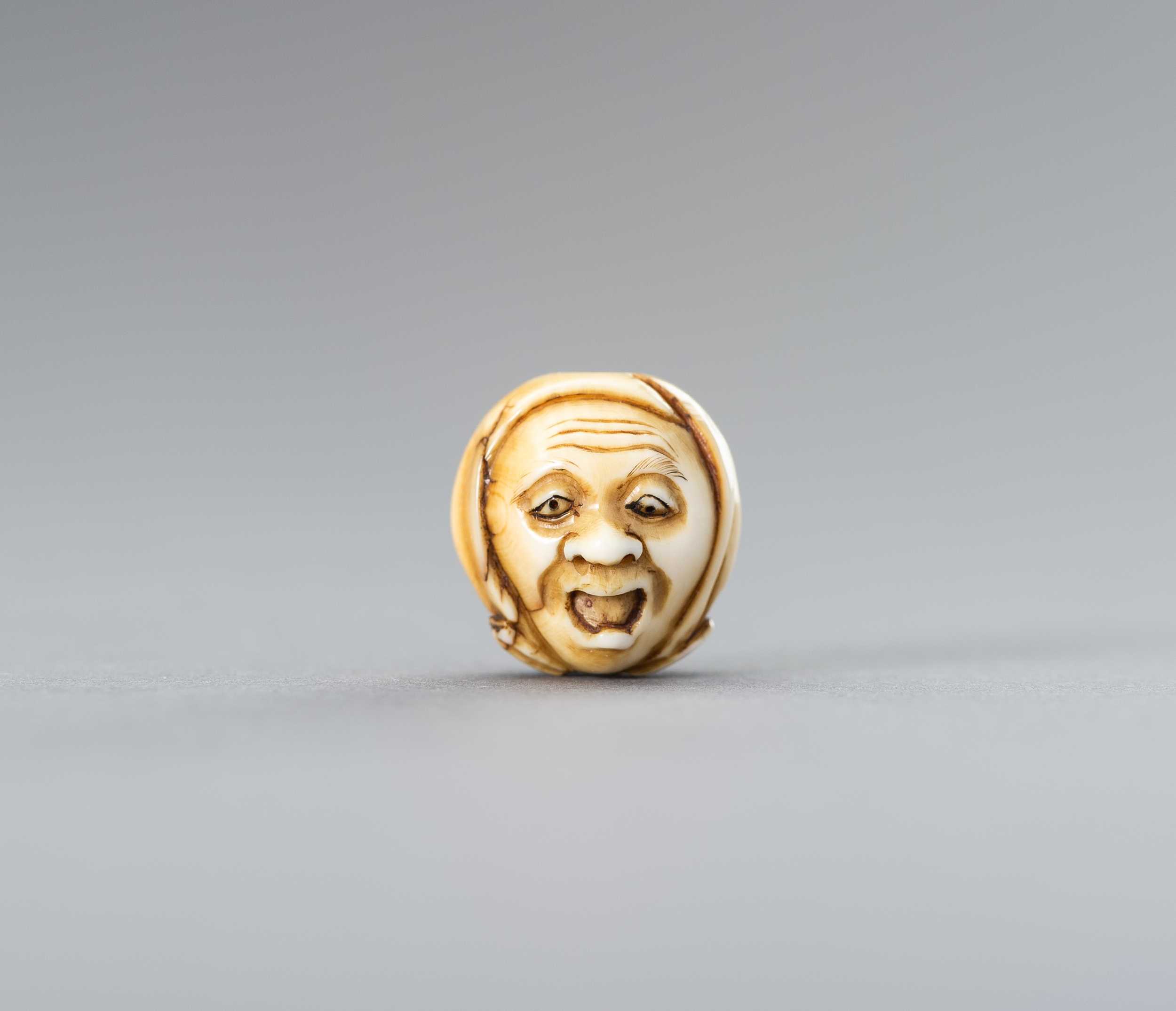 Lot 604 - AN IVORY OJIME WITH A YAWNING MAN