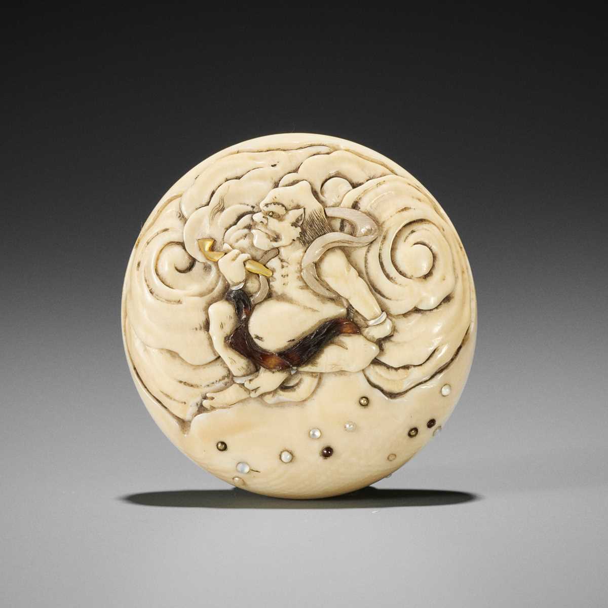 Lot 385 - SANSUI: A FINE IVORY MANJU NETSUKE DEPICTING RAIJIN WITH PIPE