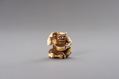 Lot 526 - AN IVORY NETSUKE OF AN ONI COMBING HIS HAIR