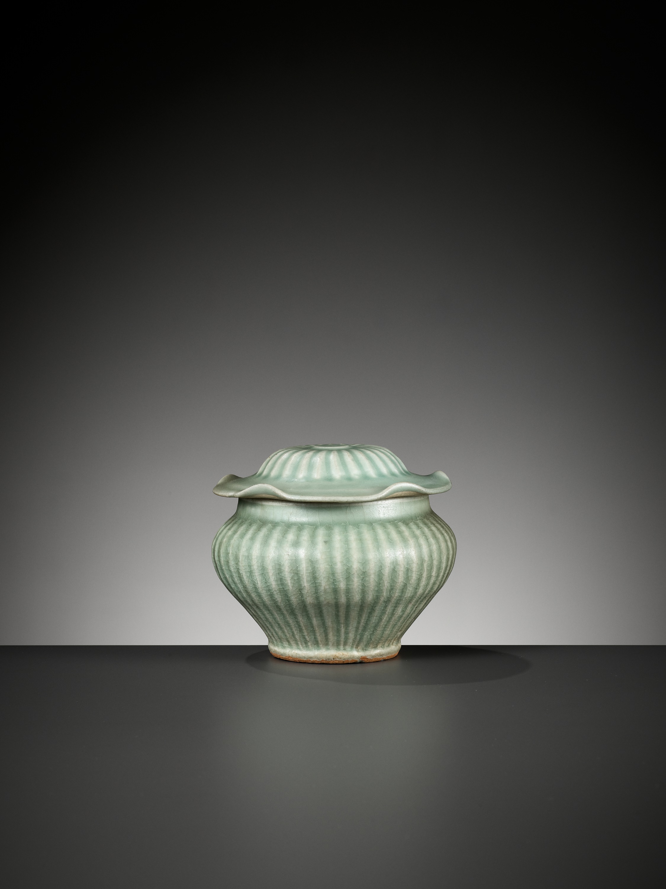 Lot 397 - A LONGQUAN CELADON RIBBED JAR AND COVER,