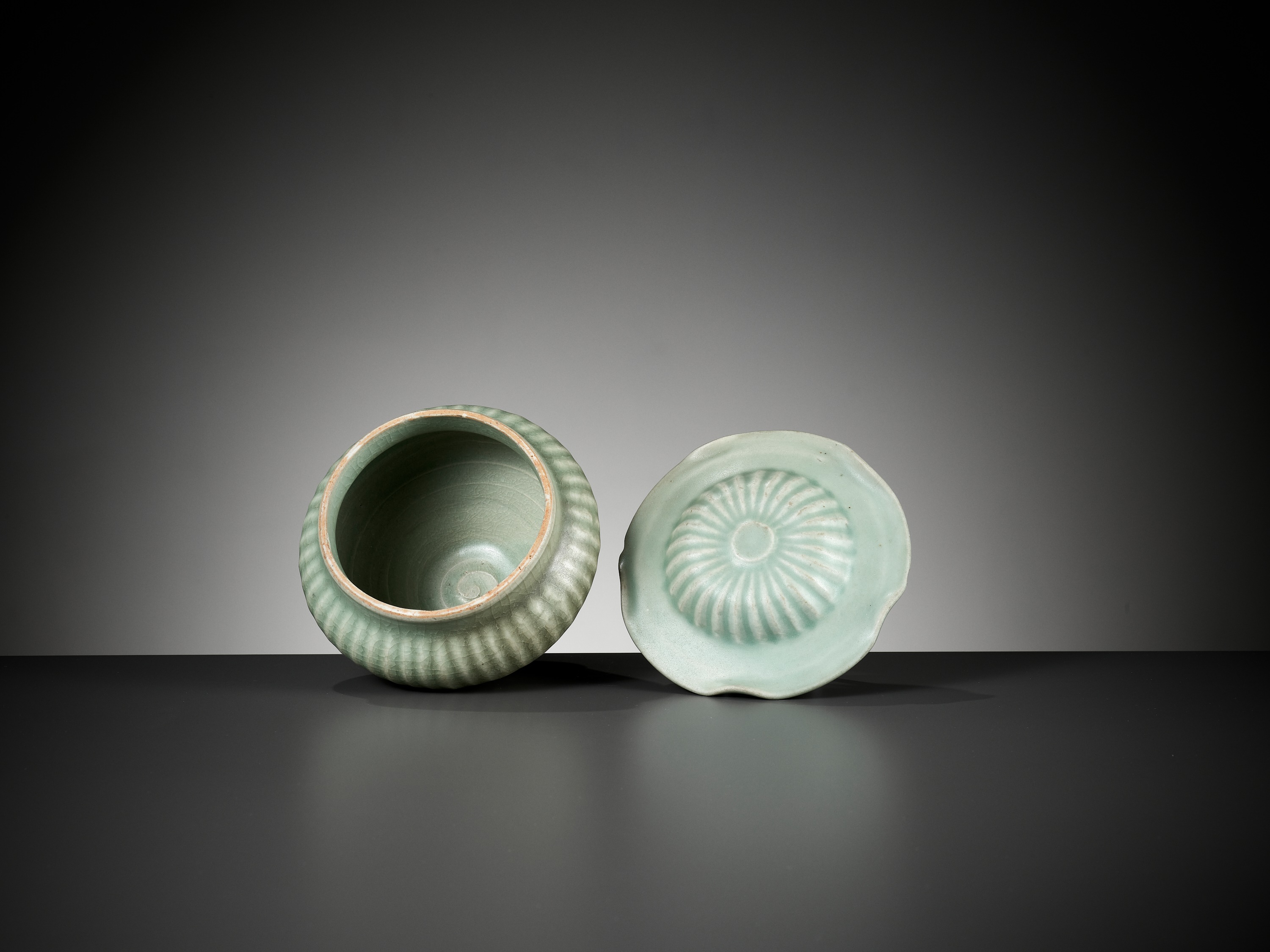 Lot 397 - A LONGQUAN CELADON RIBBED JAR AND COVER,