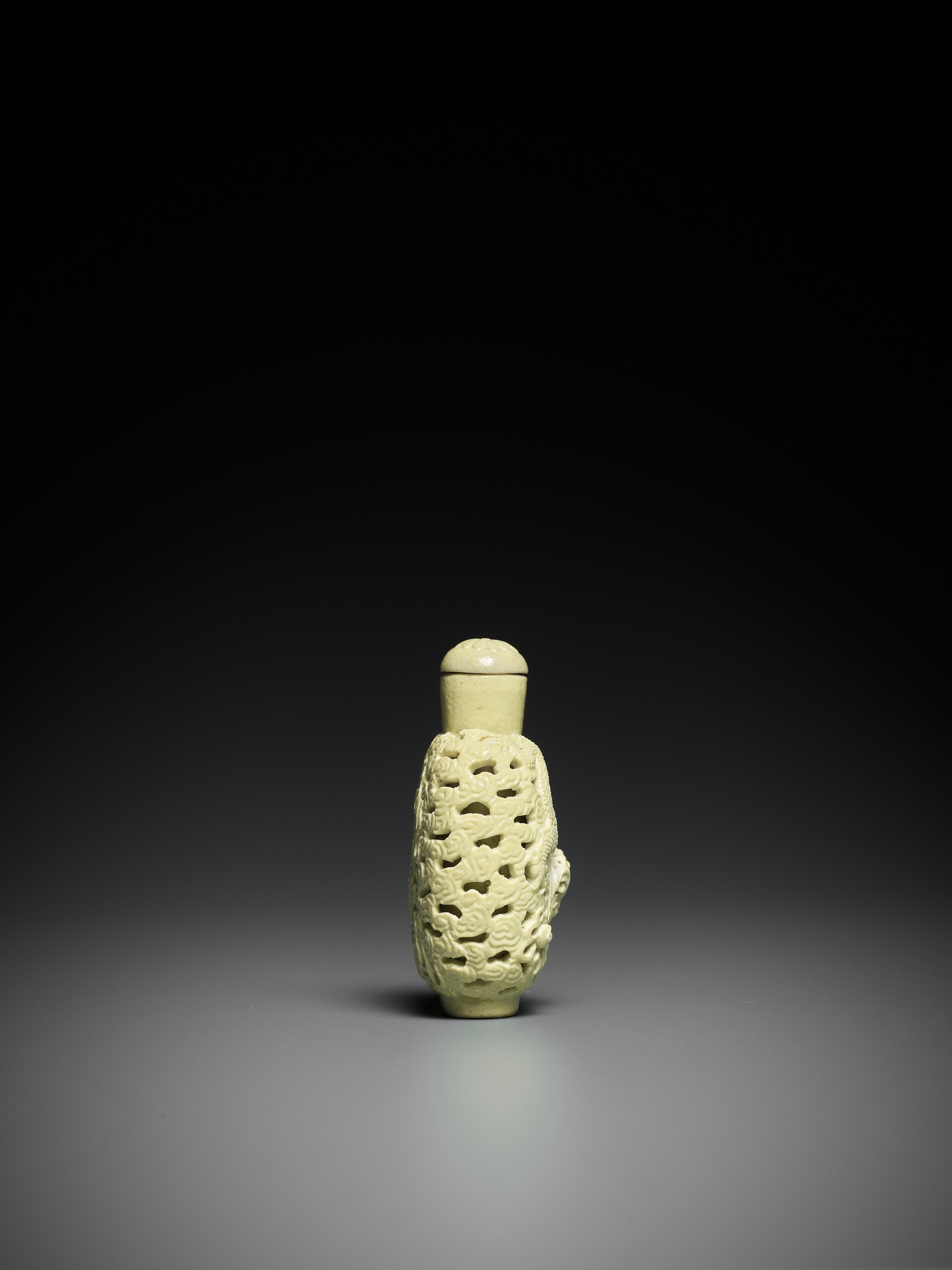 Lot 648 - A CARVED YELLOW-GLAZED 'DRAGON' SNUFF BOTTLE,