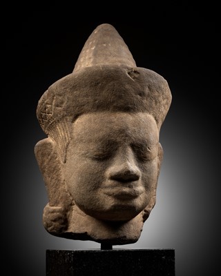 Lot 277 - A MONUMENTAL SANDSTONE HEAD OF A MALE DEITY, ANGKOR WAT STYLE