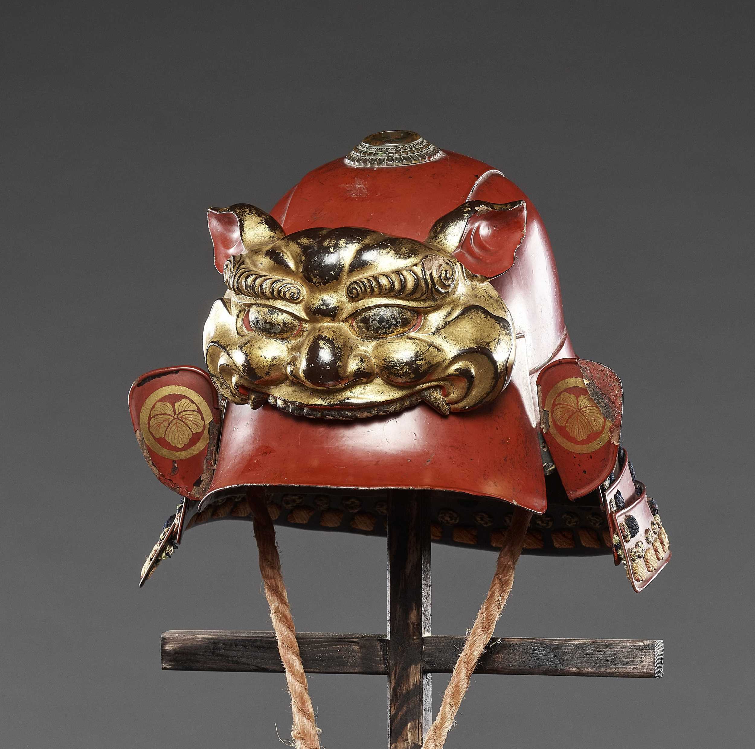 Lot 58 - A RED-LACQUERED ZUNARI KABUTO WITH LION MASK MAEDATE