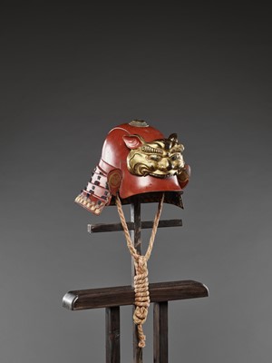Lot 58 - A RED-LACQUERED ZUNARI KABUTO WITH LION MASK MAEDATE