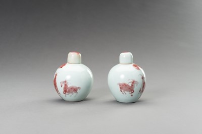 Lot 380 - A RARE PAIR OF COPPER-RED, LIDDED PORCELAIN JARLETS DEPICTING GOATS, 1900s