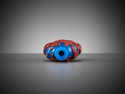 Lot 618 - A CINNABAR-RED OVERLAY BLUE GLASS ‘DRAGON’ SNUFF BOTTLE, 1780-1860