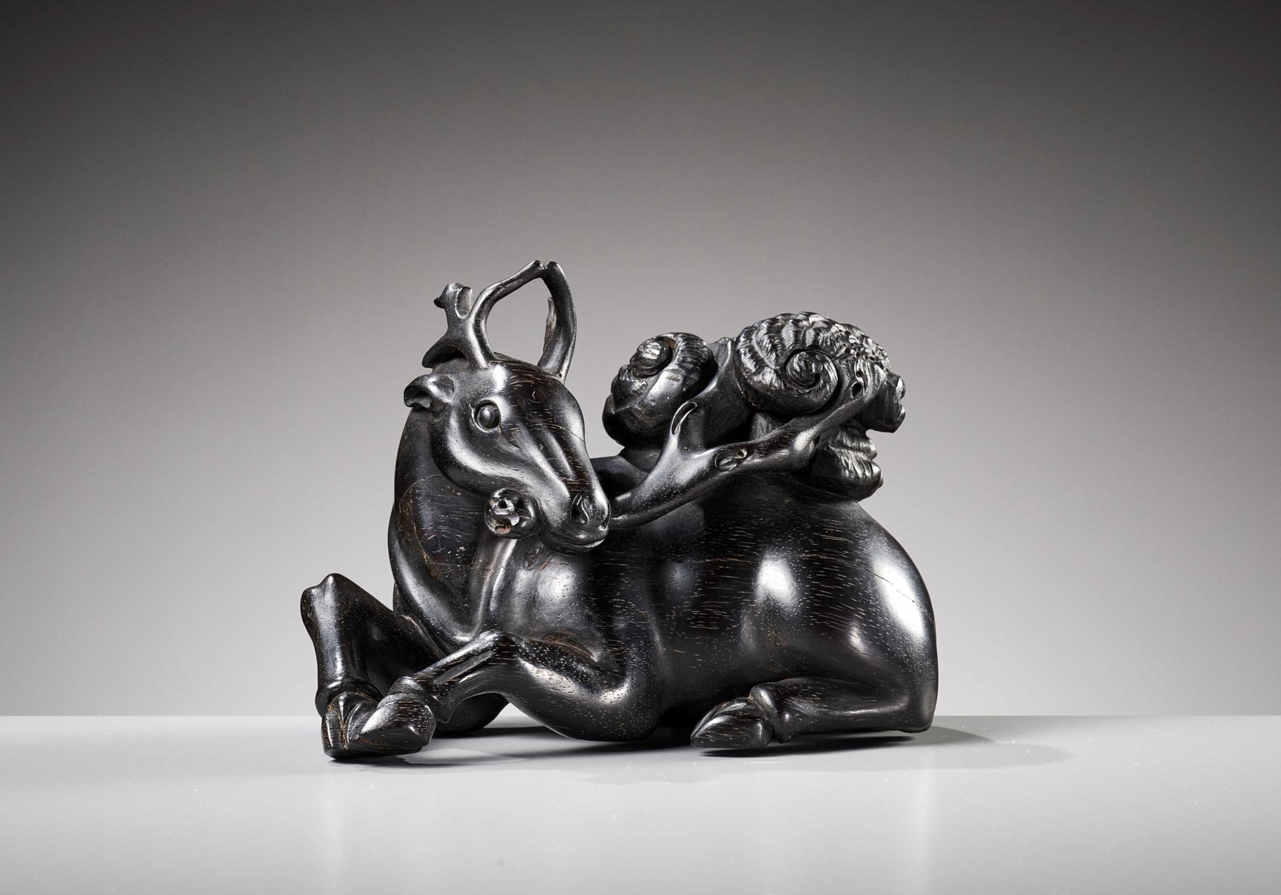Lot 21 - A ZITAN FIGURE OF A DEER HOLDING LINGZHI, 18TH CENTURY