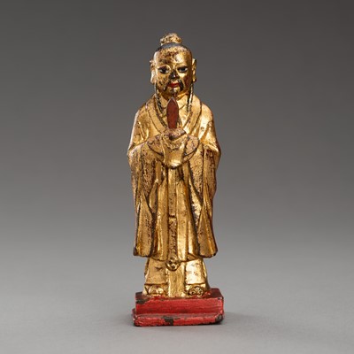 Lot 719 - A GILT-LACQUERED BRONZE FIGURE OF AN OFFICIAL, QING OR EARLIER