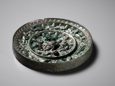 Lot 481 - A SILVERY BRONZE ‘LION AND GRAPEVINE’ MIRROR, TANG DYNASTY