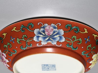 Lot 82 - A FALANGCAI ‘PEONIES AND WUFU’ CORAL-GROUND DISH, QIANLONG MARK AND PERIOD