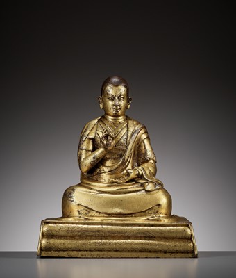Lot 179 - AN INSCRIBED GILT BRONZE FIGURE OF A LAMA, 17TH-18TH CENTURY