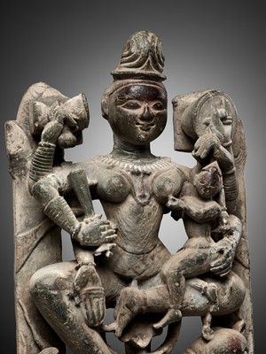 Lot 704 - A GRAY SCHIST RELIEF OF THE JAIN GODDESS AMBIKA WITH HER COMPANION, THE LION
