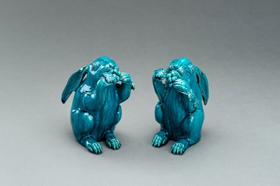 Lot 593 - A PAIR OF TURQUOISE GLAZED CERAMIC FIGURES OF RABBITS EATING BERRIES