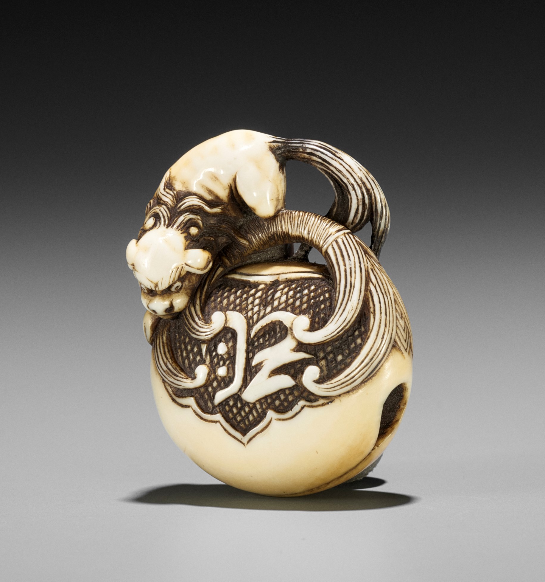 Lot 1533 - A FINE IVORY NETSUKE OF A SHISHI ON MOKUGYO
