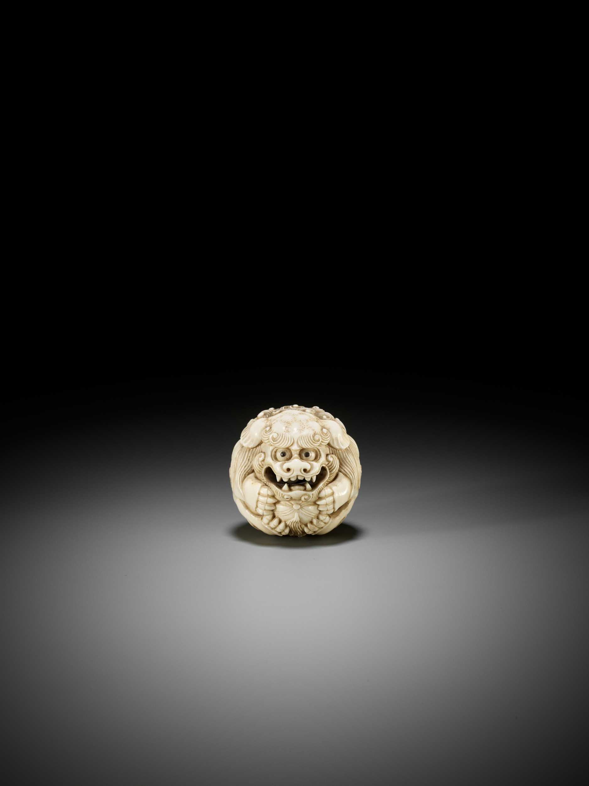 Lot 233 - AN IVORY NETSUKE OF A SHISHI BALL