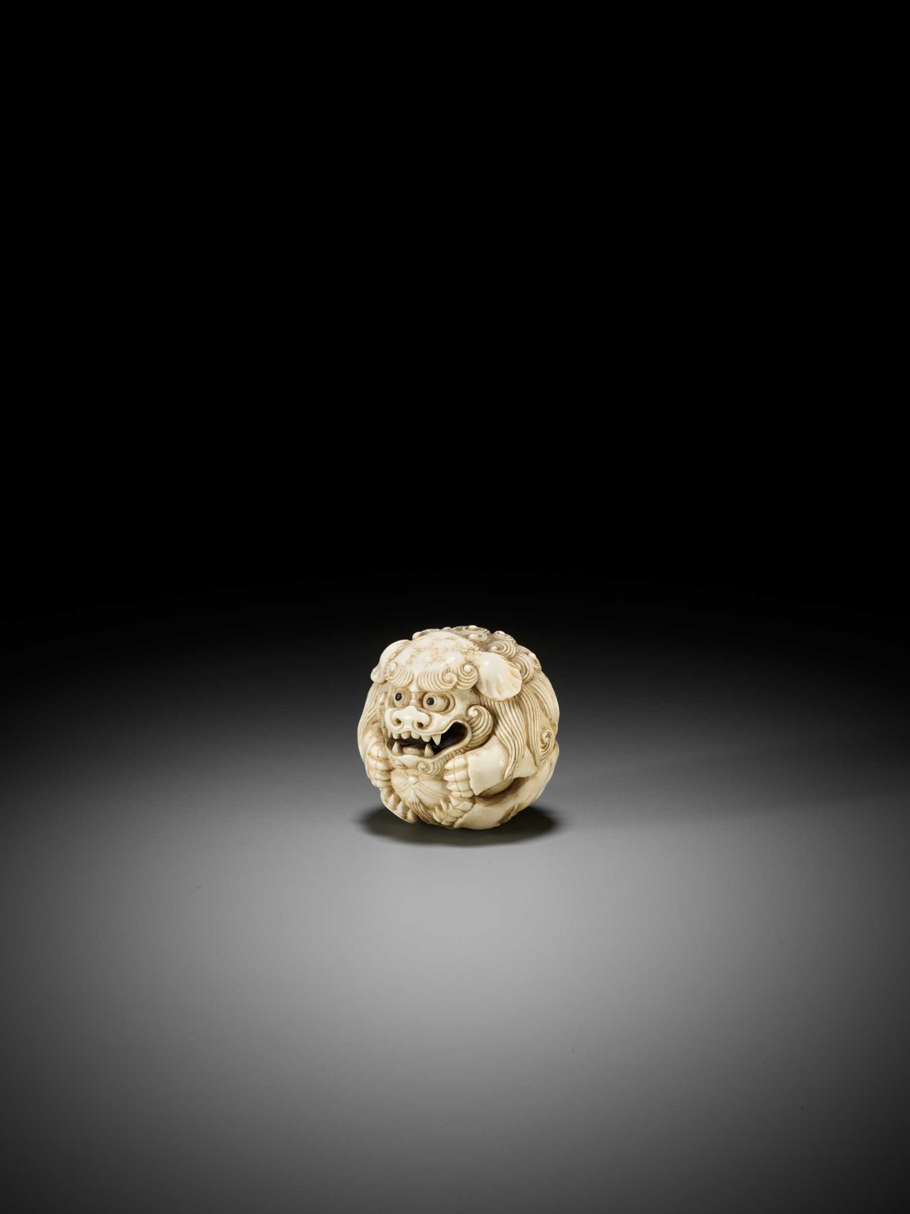 Lot 233 - AN IVORY NETSUKE OF A SHISHI BALL