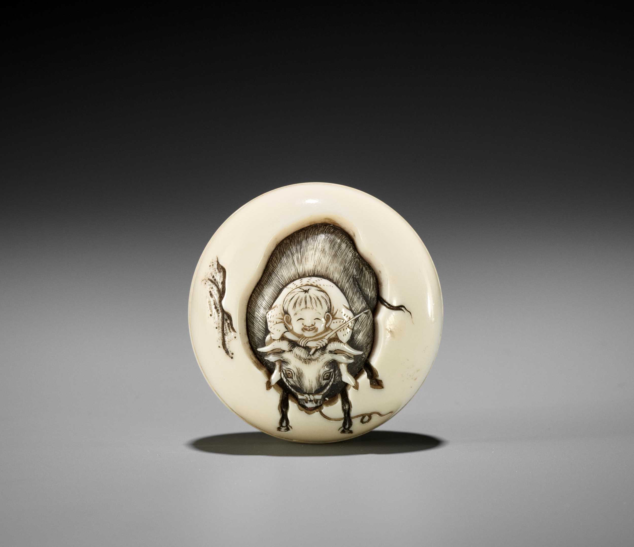 Lot 133 - KOJU: A FINE MANJU NETSUKE OF A BOY AS AN OX HERDER