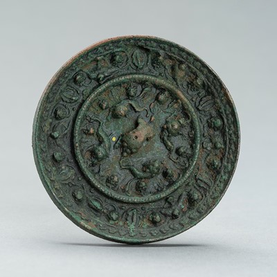 Lot 311 - A TANG DYNASTY BRONZE ‘LION AND GRAPEVINE’ MIRROR