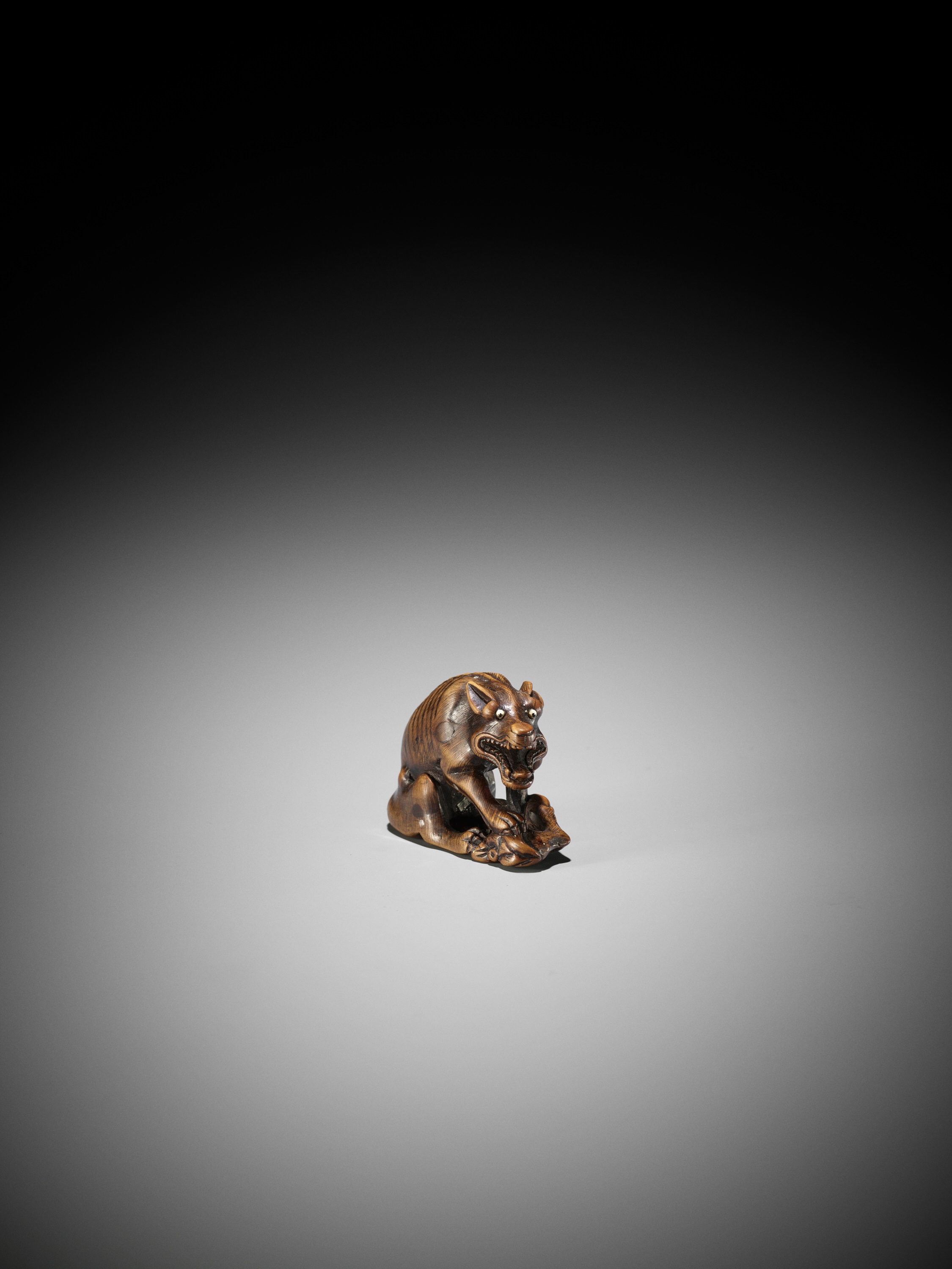 Lot 240 - MASATOMO: A WOOD NETSUKE OF A WOLF WITH