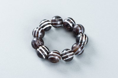 Lot 877 - AN ANCIENT BURMESE GHOST EYE AGATE BRACELET