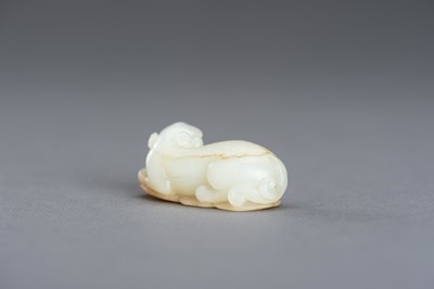 Lot 140 - A WHITE AND RUSSET JADE PENDANT OF A BUDDHIST LION, QING DYNASTY