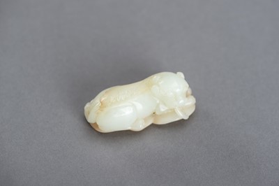 Lot 140 - A WHITE AND RUSSET JADE PENDANT OF A BUDDHIST LION, QING DYNASTY