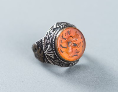 Lot 1018 - AN AGATE INTAGLIO INSET PERSIAN SILVER RING