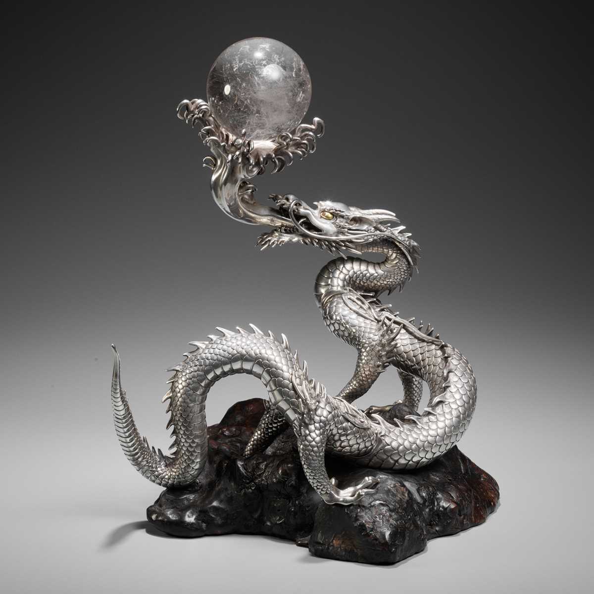 Lot 54 - SANMI: A MASTERFUL SILVER OKIMONO OF A DRAGON WITH ROCK CRYSTAL SPHERE