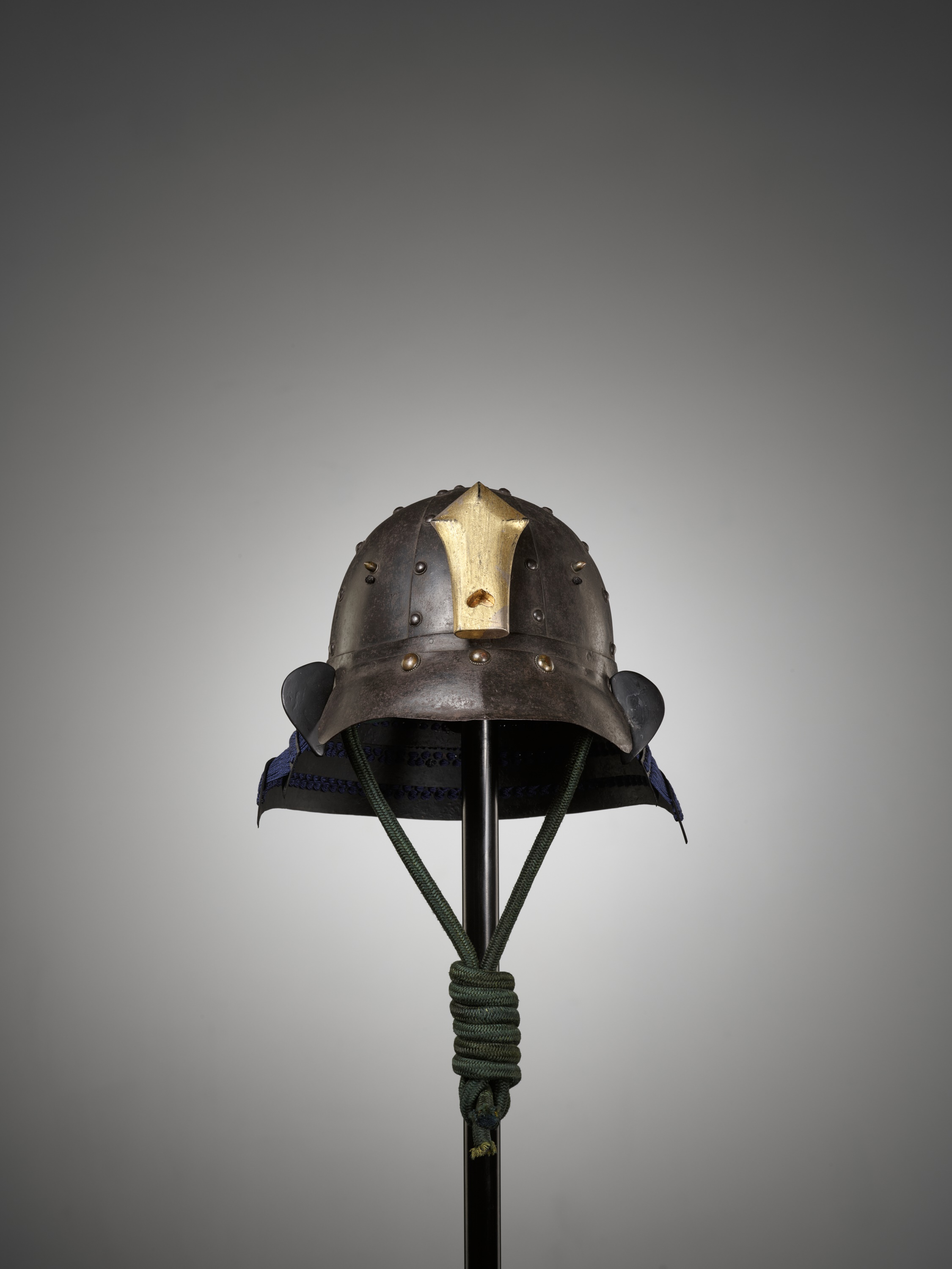 Lot 393 - AN IRON SAIGA BACHI KABUTO WITH GILT-WOOD