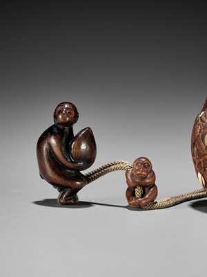 Lot 180 - SHUOSAI: AN INLAID WOOD TONKOTSU DEPICTING MONKEYS AND PEACHES WITH EN-SUITE NETSUKE AND OJIME