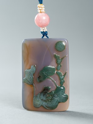 Lot 892 - AN AGATE PLAQUE PENDANT CARVED WITH A LOTUS POND