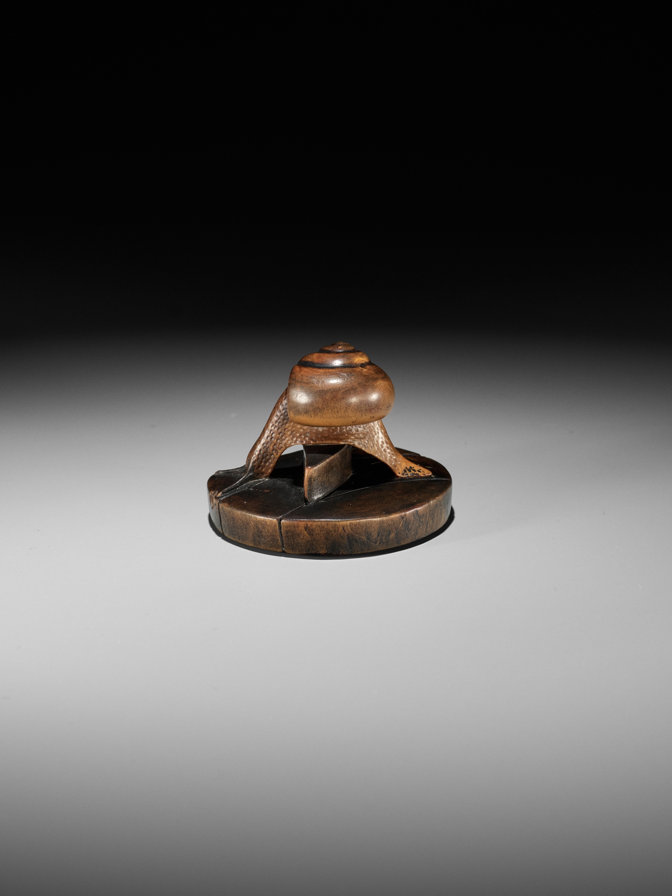 Lot 105 - TOMOSHIGE: A RARE WOOD NETSUKE OF A SNAIL ON