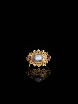 Lot 657 - A GOLD PRIEST’S RING INLAID WITH A MOONSTONE AND TWO SMALL GARNETS